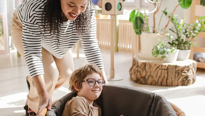 A support worker chatting with a smiling young boy